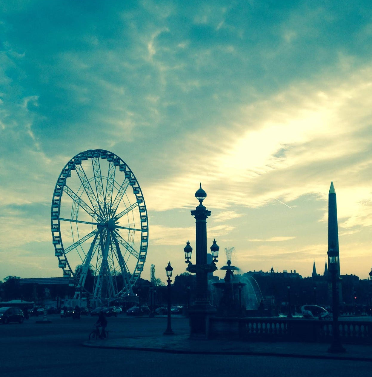 Ferris wheel and cityscape with sunset or sunrise, blue sky with clouds
